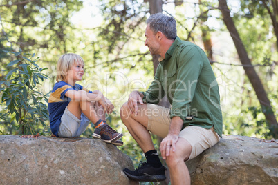 Father and talking while siting on rocks