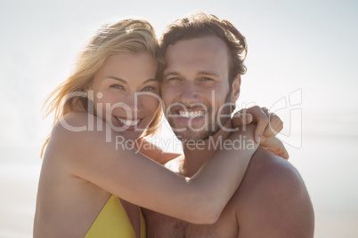 Portrait of happy couple embracing at beach