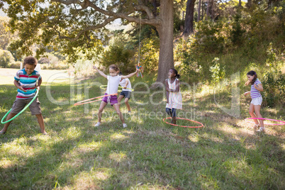 Group of friends playing with hula hoops at campsite