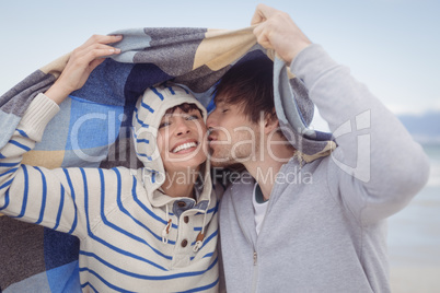 Young man kissing his girlfriend during winter