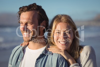 Smiling woman with boyfriend standing at beach