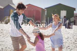 Happy multi-generation family holding hands at beach