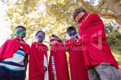 Friends in superhero costumes standing at campsite