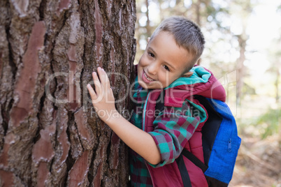 Portrait of happy boy embracing tree