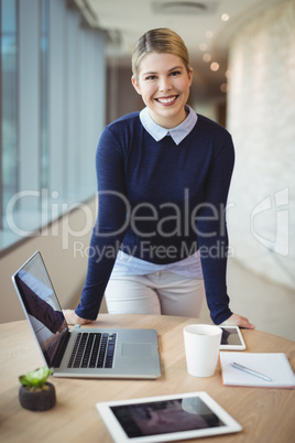 Portrait of smiling executive standing at desk