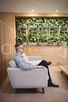 Thoughtful executive sitting on sofa in lobby