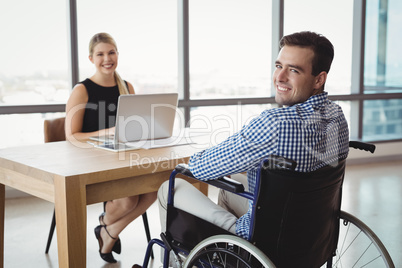 Portrait of smiling executives at desk