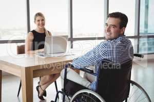 Portrait of smiling executives at desk