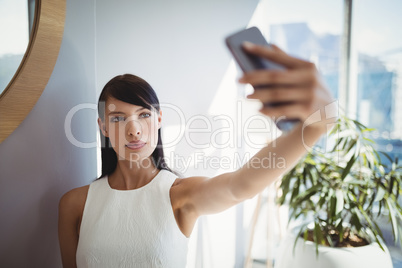 Beautiful executive taking selfie from mobile phone