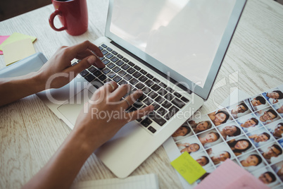 Hands of female photo editor working on laptop in office