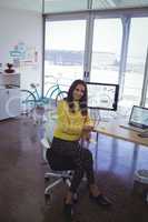 Portrait of confident businesswoman sitting at office desk