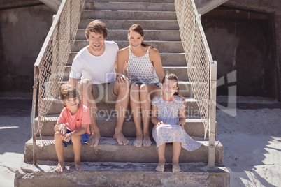 Smiling family sitting on staircase