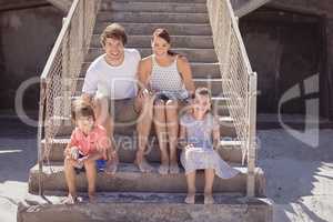 Smiling family sitting on staircase