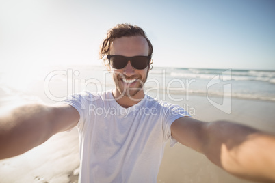 Portrait of smiling young man wearing sunglasses at beach