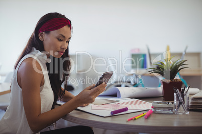 Businesswoman using mobile phone at creative office