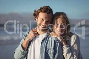 Portrait of smiling couple standing at beach