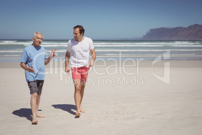 Man talking with his father while walking at beach