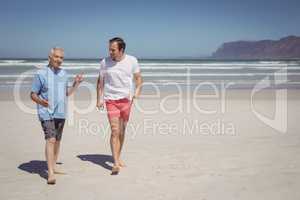 Man talking with his father while walking at beach