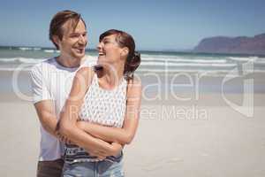 Cheerful couple embracing at beach