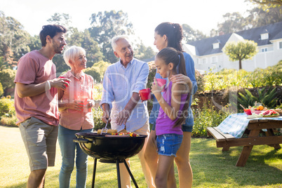 Family talking while preparing barbecue in the park