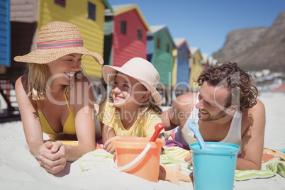 Happy family lying on blanket at beach