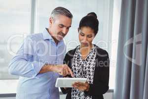 Executives discussing over digital tablet