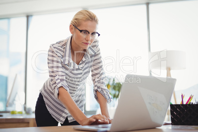 Attentive executive using laptop at desk