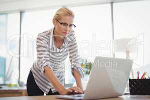 Attentive executive using laptop at desk