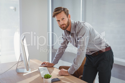 Portrait of confident executive working on personal computer at desk