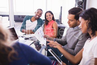 Portrait of business people sitting with colleagues