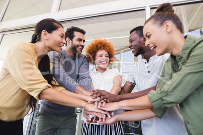 Cheerful business colleagues stacking hands