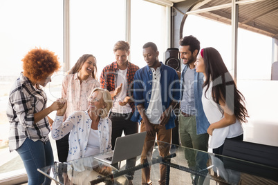 Happy businesswoman with coworkers at creative office