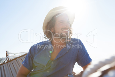 Smiling man relaxing on hammock at beach