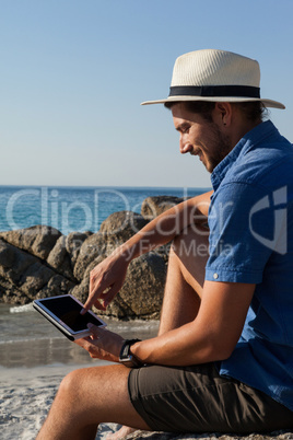 Man using digital tablet on the beach