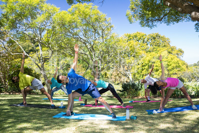 Group of people performing stretching exercise in the park