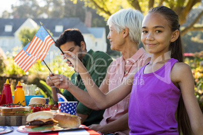 Girl holding american flag near the picnic table