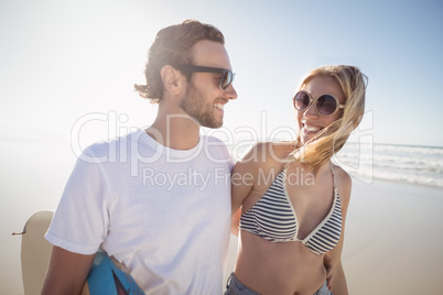 Happy young couple wearing sunglasses at beach