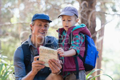 Man and boy reading map in forest