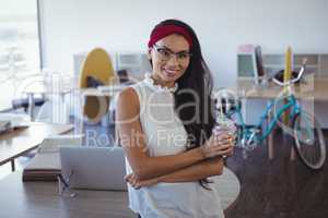 Portrait of young businesswoman holding drink at office