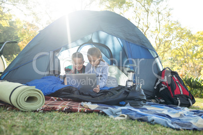 Kids using laptop in the tent