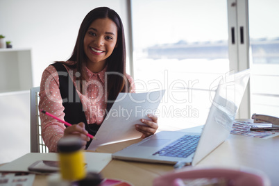 Portrait businesswoman holding document at creative office
