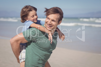 Happy father piggybacking his son at beach
