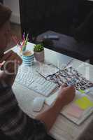 Male photo editor writing in book on desk