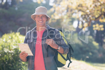 Portrait of happy male hiker with map