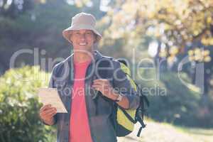 Portrait of happy male hiker with map