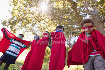Friends enjoying while wearing superhero costume at campsite