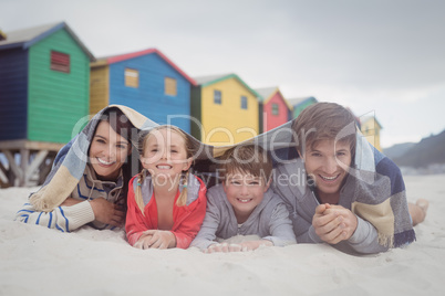 Portrait of happy family lying on sand