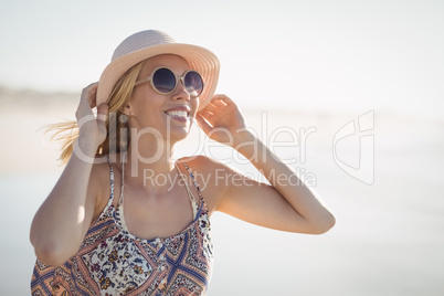 Young woman wearing sunglasses and hat at beach