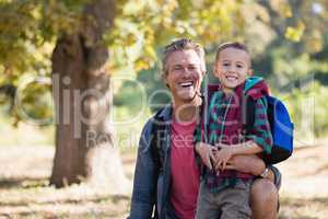 Portrait of happy father and son in forest