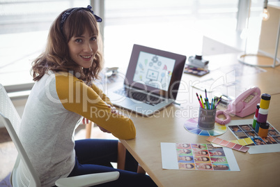 High angle portrait of smiling businesswoman sitting at office desk